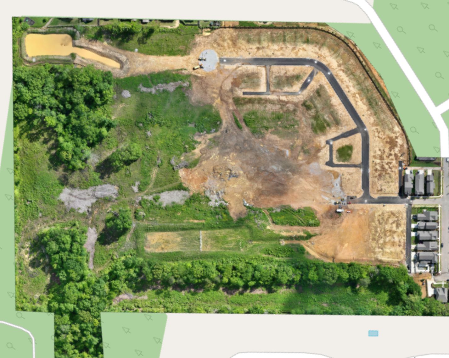 Overhead orthomosaic of The Farmstead Phase 2 showing the completed street network, graded lots, detention pond and preserved woodland
