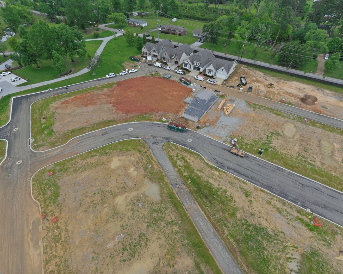 Aerial view of new curb and asphalt streets with graded lots
