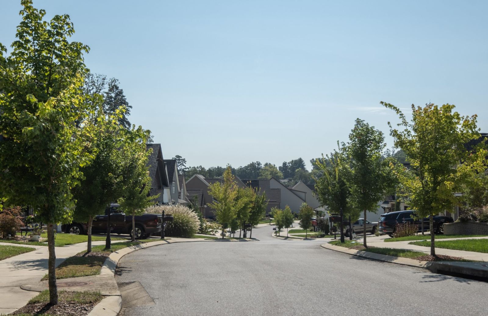 Neighborhood intersection with homes and a manhole cover in the roadway