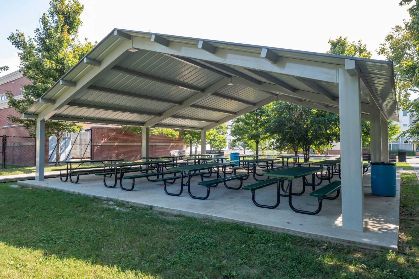 Park benches and a table under mature shade trees